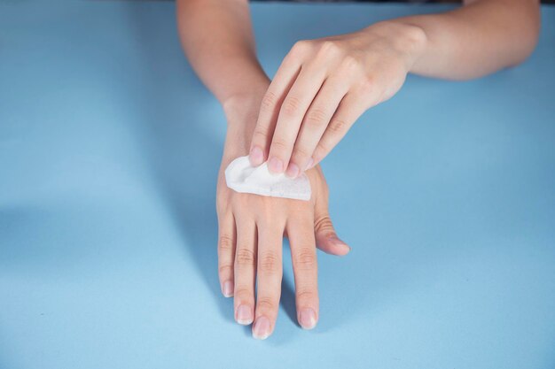 Woman cleaning hands with a napkin