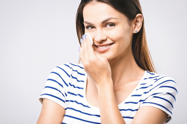 Woman cleaning her face with cotton pads