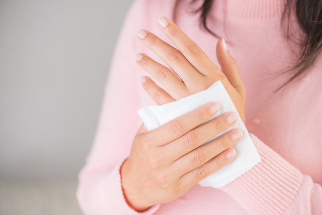 Woman cleaning her hands with a tissue. Healthcare concept.