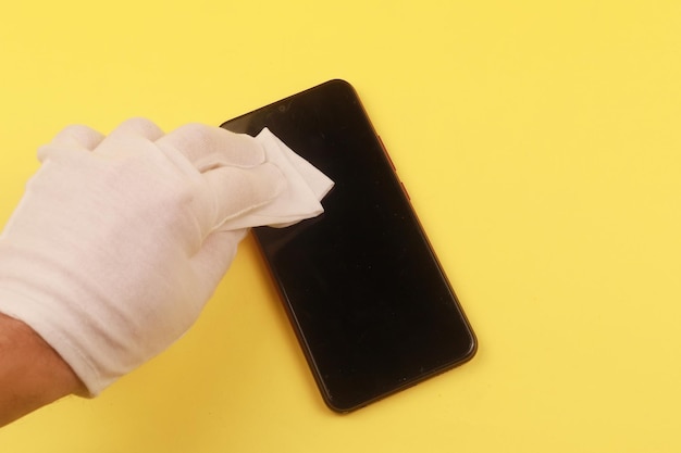 Woman cleaning mobile phone with antiseptic wipe