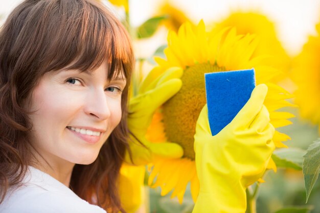 Woman cleaning sunflower outdoors Ecology concept