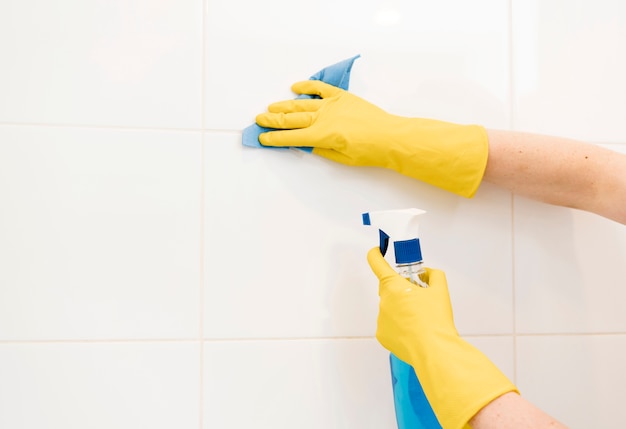 Photo woman cleaning wall tiles