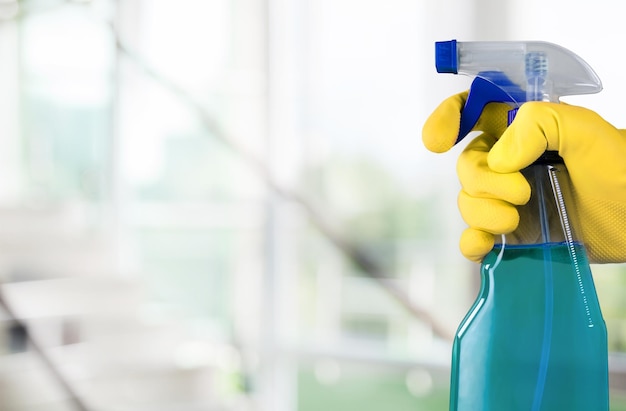 Woman cleaning a window with cleaning sprayer.