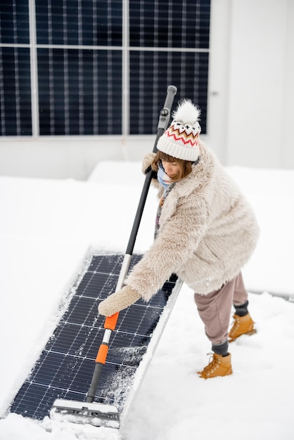 Photo woman cleans solar panels from snow