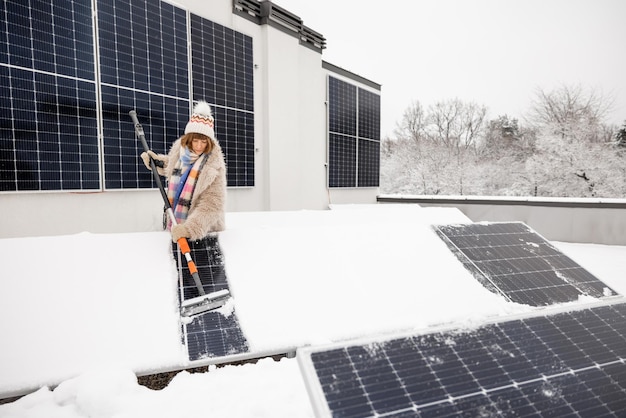 Woman cleans solar panels from snow