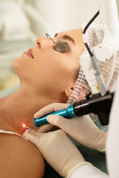 Woman client during laser removal of pigmentation or birthmarks in a medical aesthetic clinic