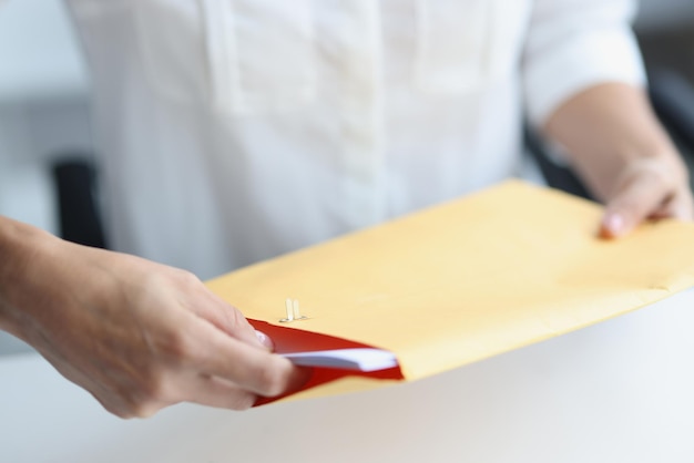 Woman client reads news in paper envelope at home desk online shopping and business mail