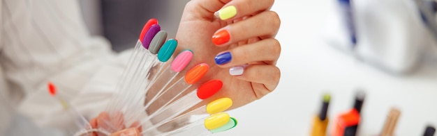 Woman client with palette of nail varnishes in beauty shop