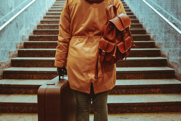 Woman climb stairs with bags at railway station