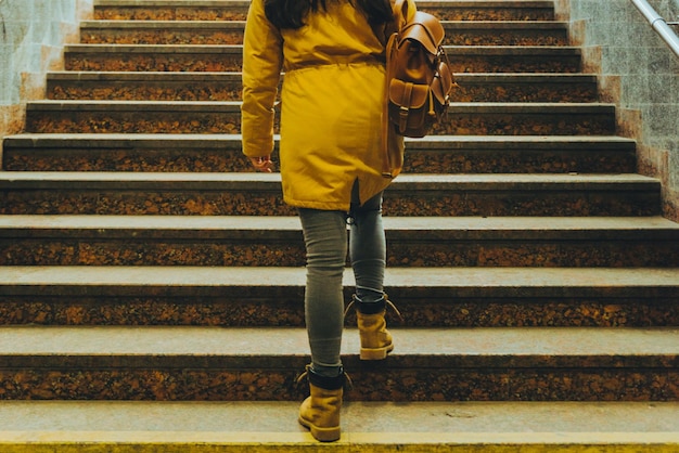 Woman climb stairs with bags at railway station