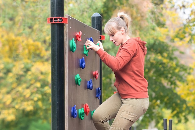 A woman climbed onto an artificial climbing wall healthy lifestyle concept active recreation outdoor