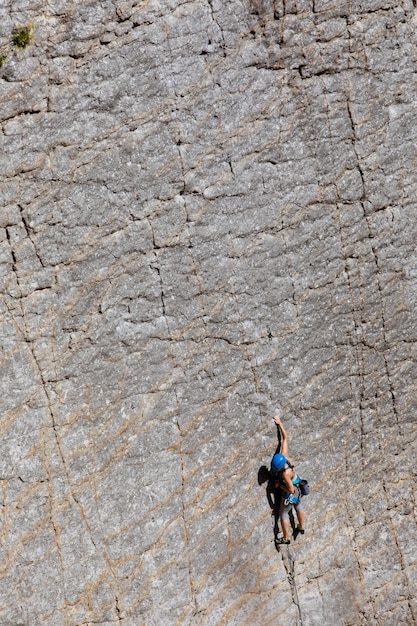 Photo woman climbing on an abrupt mountain