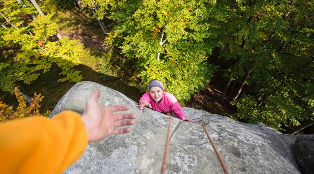 Donna che si arrampica nella natura sul grande masso