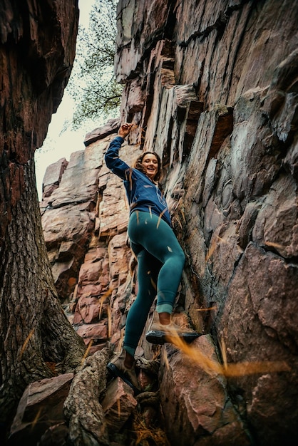 A woman climbing a rock face in the mountains