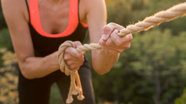 Foto donna che si arrampica con l'aiuto di una corda