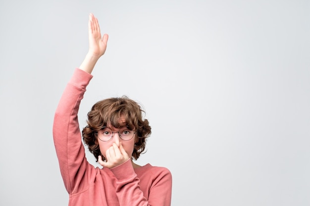 Woman closes her nose with fingers showing like she is going under water or sinking