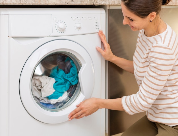 Photo woman closing door of washing machine