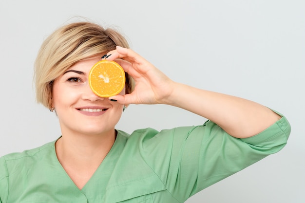 Woman closing eye with orange