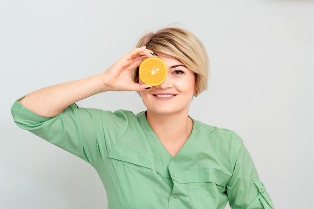 Woman closing eye with orange.