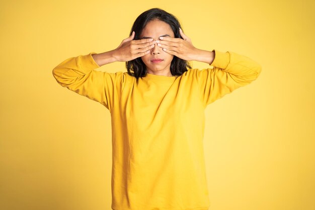 Woman closing eyes with both palms on isolated background