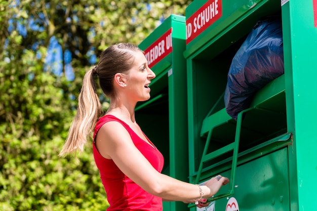 Woman at clothes recycling skip