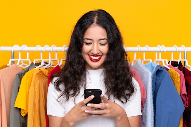 Donna in un negozio di abbigliamento e parlare al cellulare