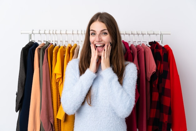 Woman in a clothing store with lots of clothes behind