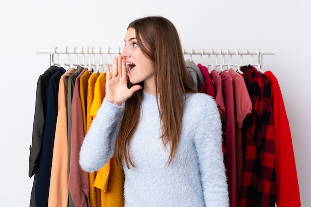 たくさんの服の後ろに衣料品店の女性