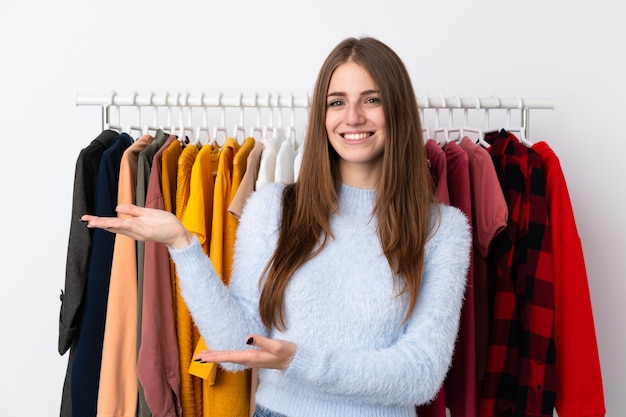 Woman in a clothing store with lots of clothes behind