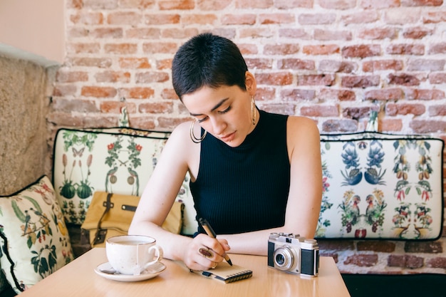 Donna ad un caffè che beve tè