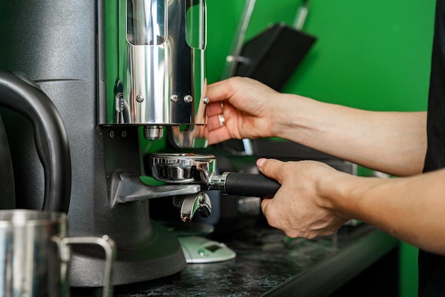 Woman coffee shop worker preparing coffee on professional coffee machine