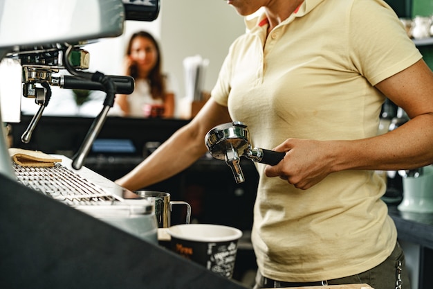 전문 커피 기계에 커피를 준비하는 여자 커피 숍 작업자
