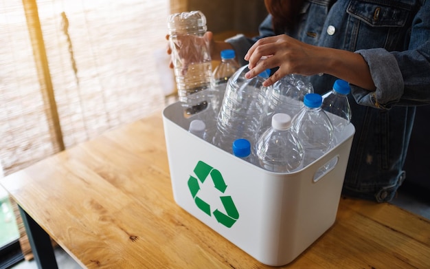 집에서 재활용 쓰레기 플라스틱 병을 모아 쓰레기통에 분리하는 여성