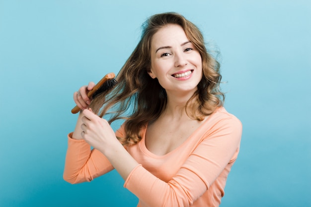 Woman combing her long hair . Hair care and creating hairstyles.