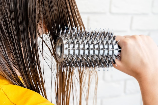 Woman combs her wet hair hair brushing