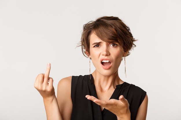 Woman complaining, looking confused and showing finger without wedding ring