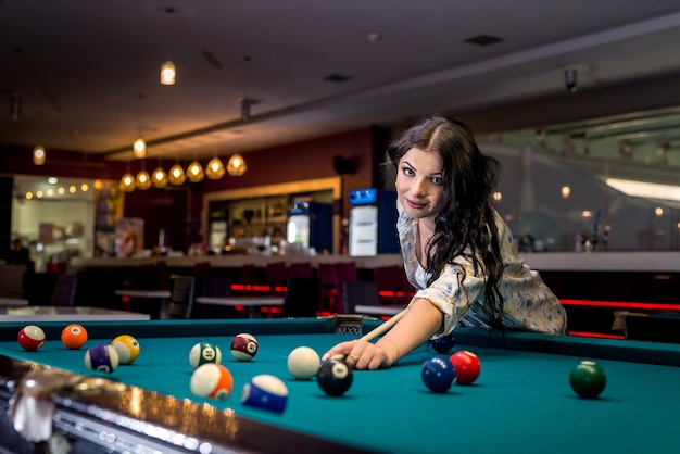 Woman concentrated on billiard game in pub