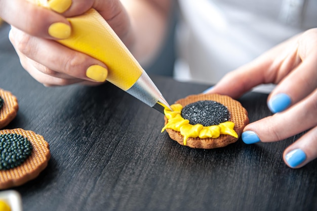 Woman confectioner making gingerbread sunflower gingerbread design