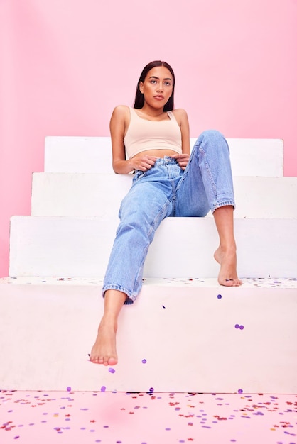 Woman confetti and steps portrait with relax style and fashion with celebration sparkle Studio pink background and female model with party event and birthday decoration with gen z confidence