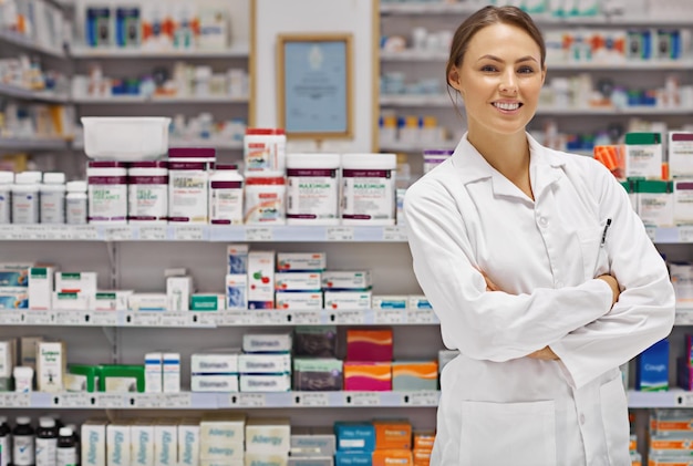 薬局の薬剤師として自信を持って腕を交わし,カスタマーサービスに誇りを持ち,薬局で薬と処方を笑顔で喜び,満足した女性の肖像画