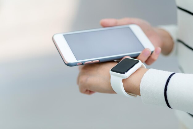 Foto la donna si connette con il cellulare e l'orologio intelligente