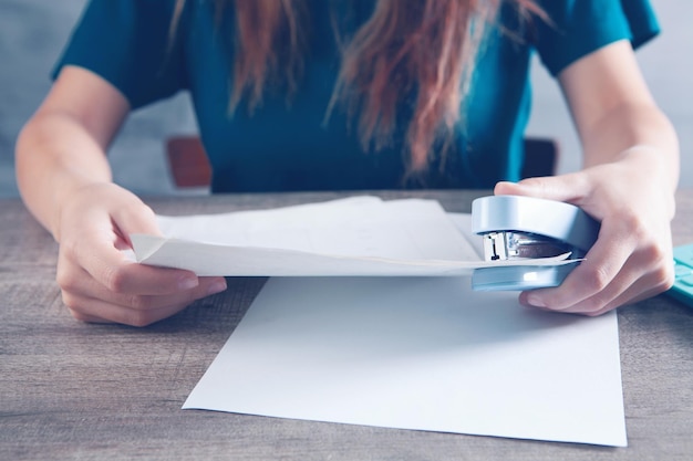 Foto la donna collega i fogli con una cucitrice