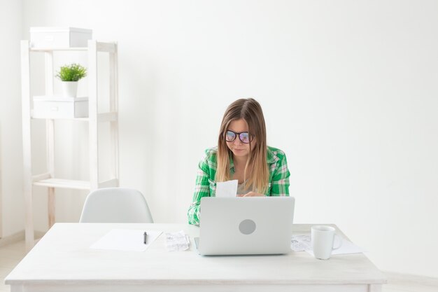 Woman considers the amount of expenses for purchases and payment of credits by entering information