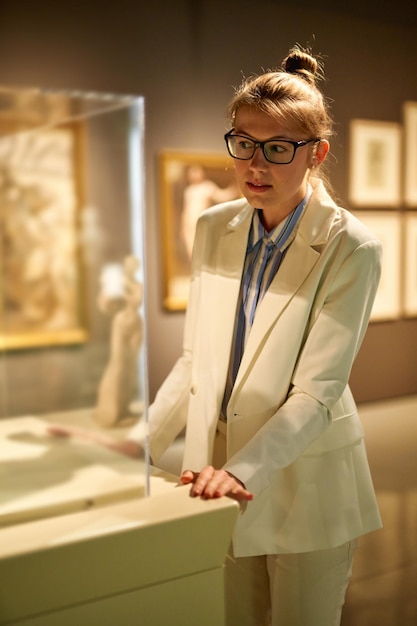 Woman considers exhibits in museum