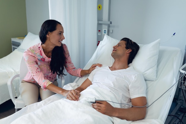 woman consoling male patient in the ward