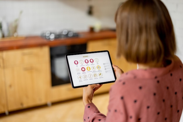 Woman controls home devices with a digital tablet at home