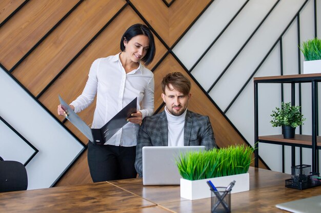 A woman controls the work of employees in the office