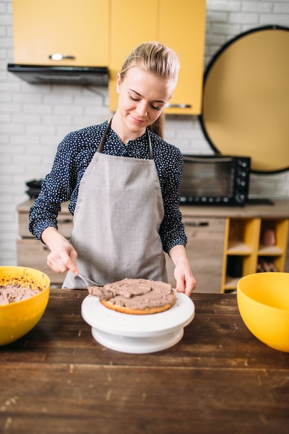 Woman cook hands smears filling for cake