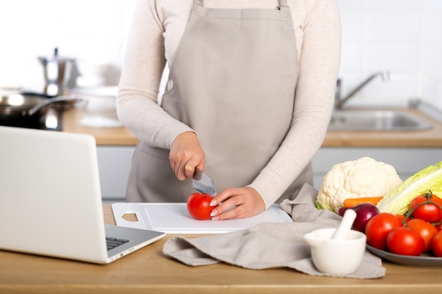 Woman cooking according the tutorial of a online virtual master class