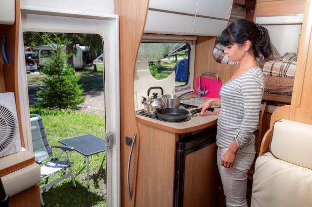 woman cooking in camper motorhome interior rv